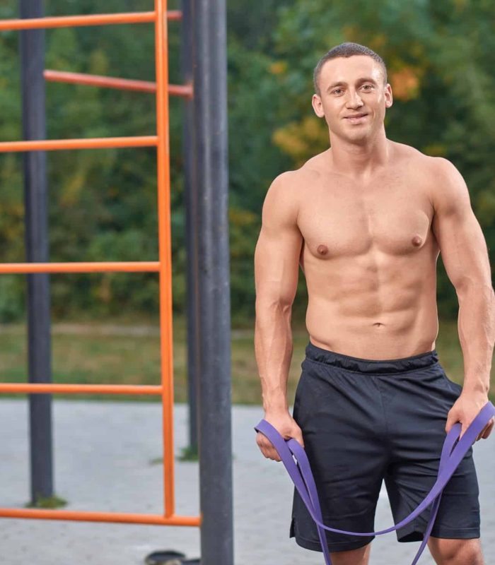 Főoldal 14 Handsome shirtless sportsman holding resistance, latex bands in hands. Attractive man posing during street workout. Muscular, athlete man standing, looking at camera, smiling.